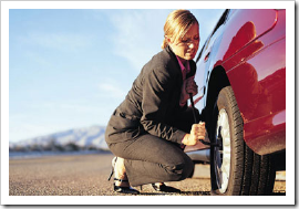 Mulher troca pneu furado